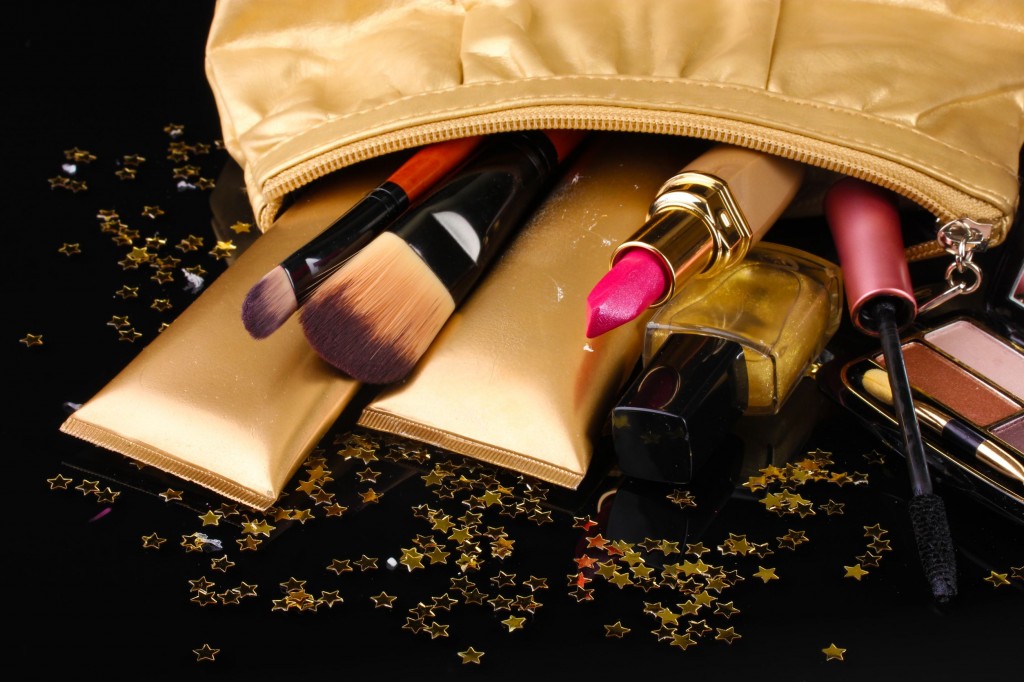 14035221 - beautiful golden makeup bag and cosmetics isolated on black