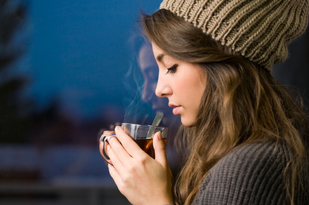 17626230 - portrait of a dreamy young brunette with hot tea.