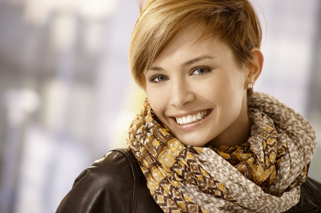 22070609 - closeup portrait of beautiful young woman wearing scarf, smiling.