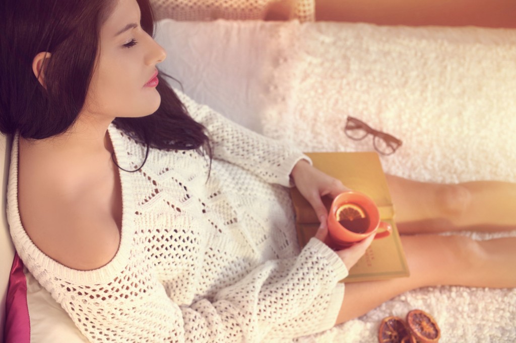 32304786 - young girl in a white sweater drinking tea with lemon
