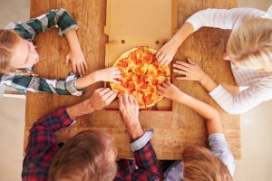 41461574 - family eating pizza together, overhead view