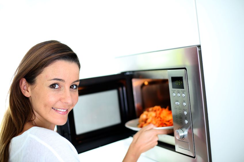19269853 - woman putting plate in microwave oven