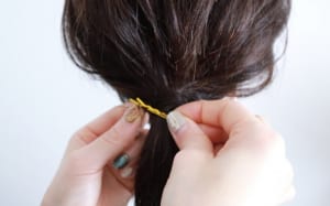 ゴムに巻きつけた毛束が4センチくらいの短さになったら、ピンの先に巻きつけていきます。巻きつける時はピンの長い部分に巻きつけた方がやりやすいです