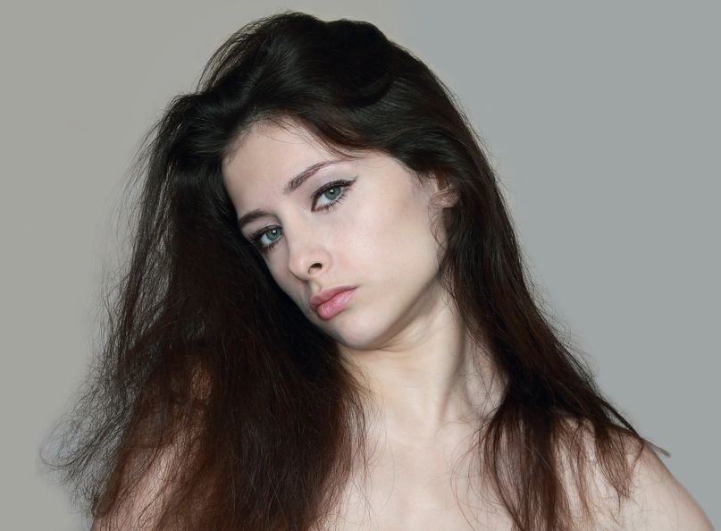 湿気による髪の広がりに悩む女性