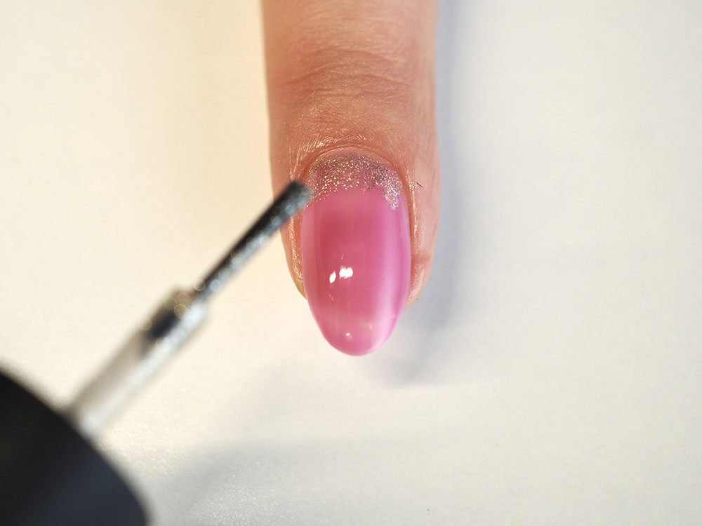 爪の甘皮側1／5くらいに、「NAIL HOLIC GD028」を塗布します。甘皮側のピンクのラインと重なるように塗布するとキレイに見えます